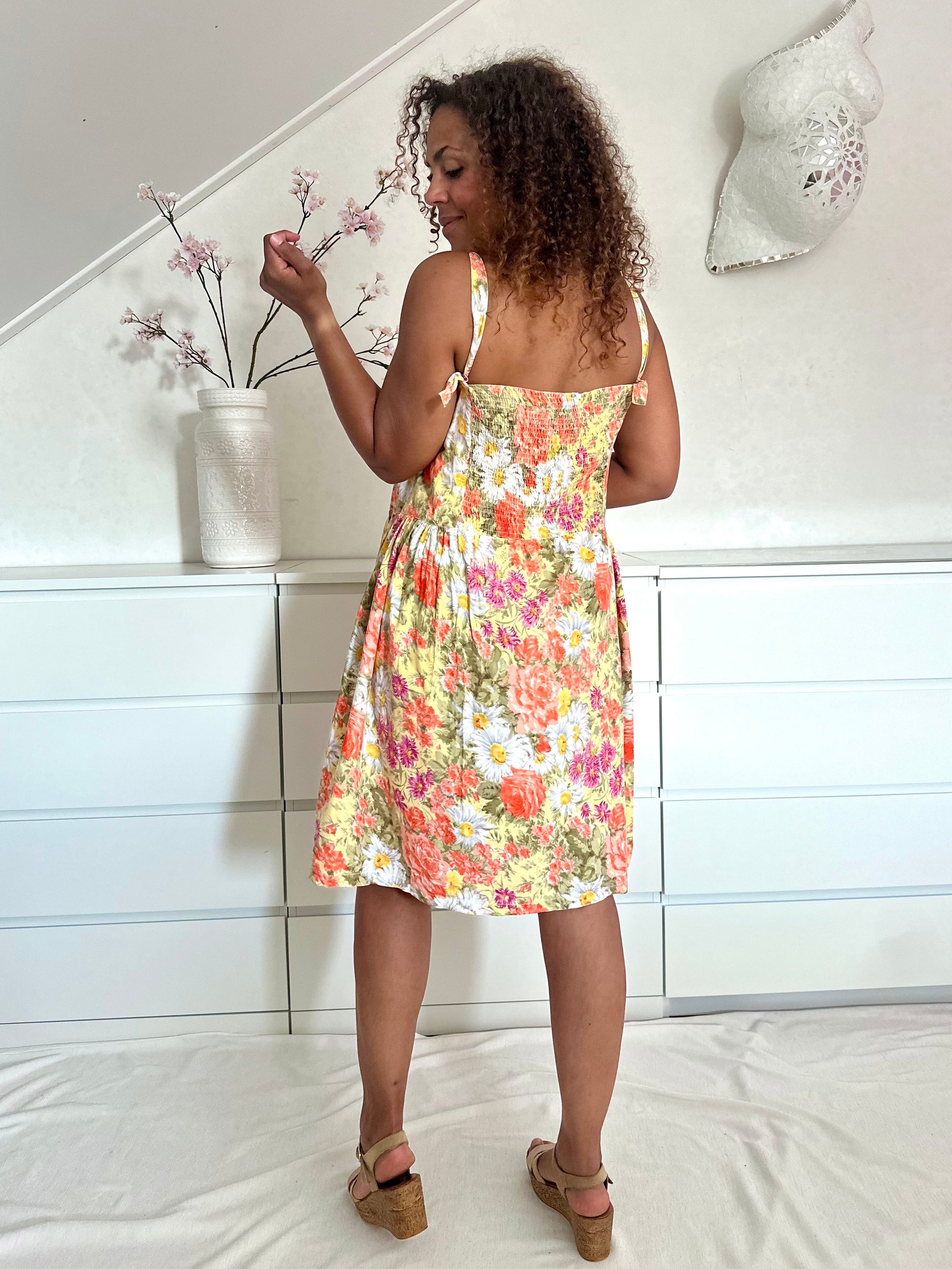 Achterkant van jaren negentig zomerjurk met spaghetti bandjes en romantische bloemenprint